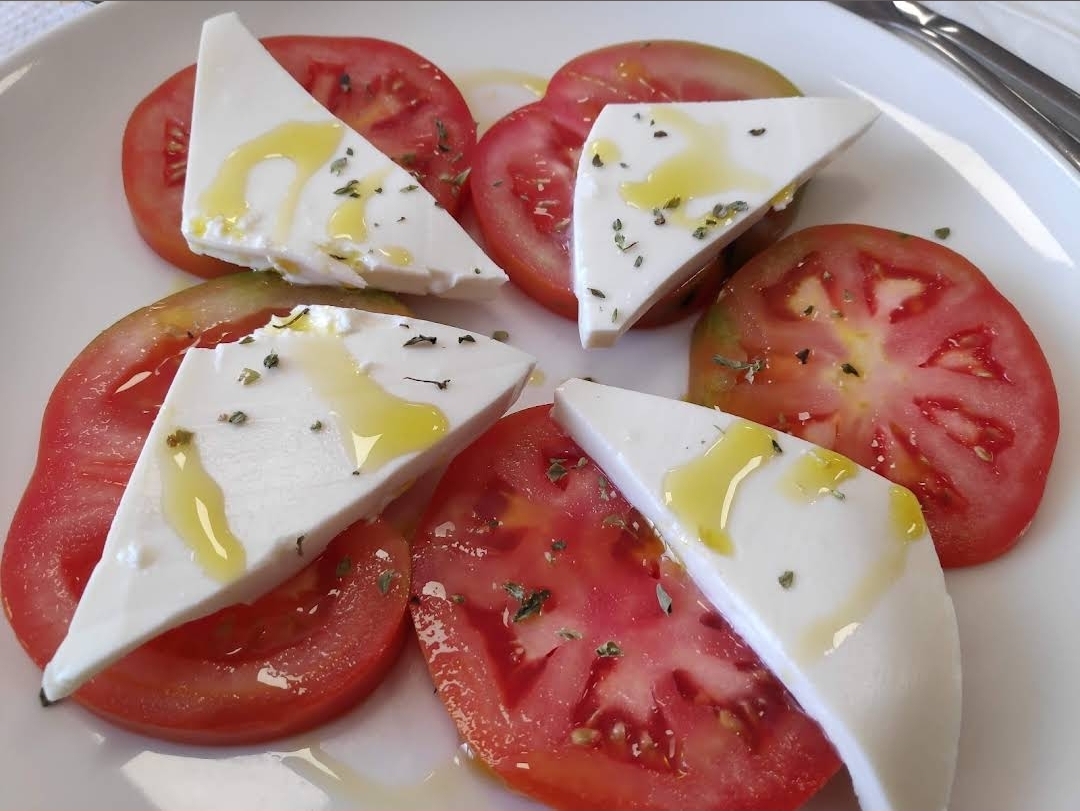 Ensalada de tomate con queso fresco, orégano y aceite de oliva