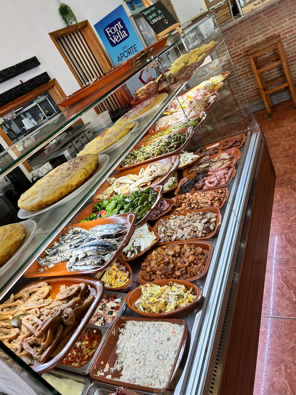 Escaparate del mostrador de Restaurante La Figuera con tortillas, ensaladas, carnes y platos caseros del día