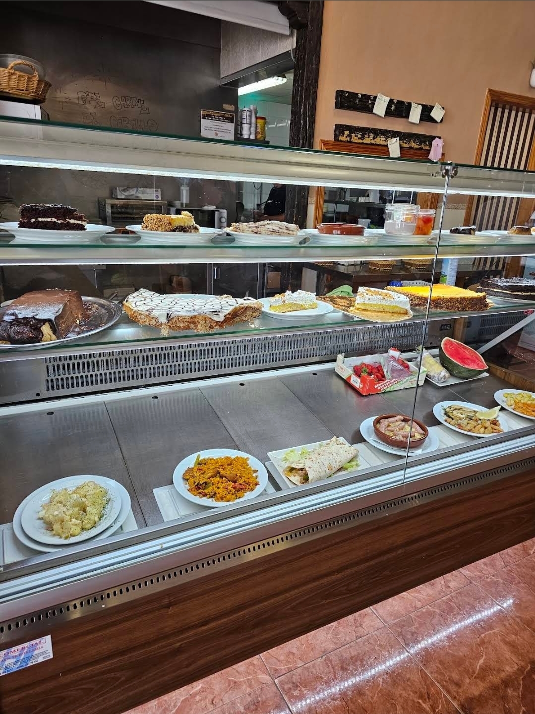 Vitrina con tartas, postres caseros y platos del día en el mostrador