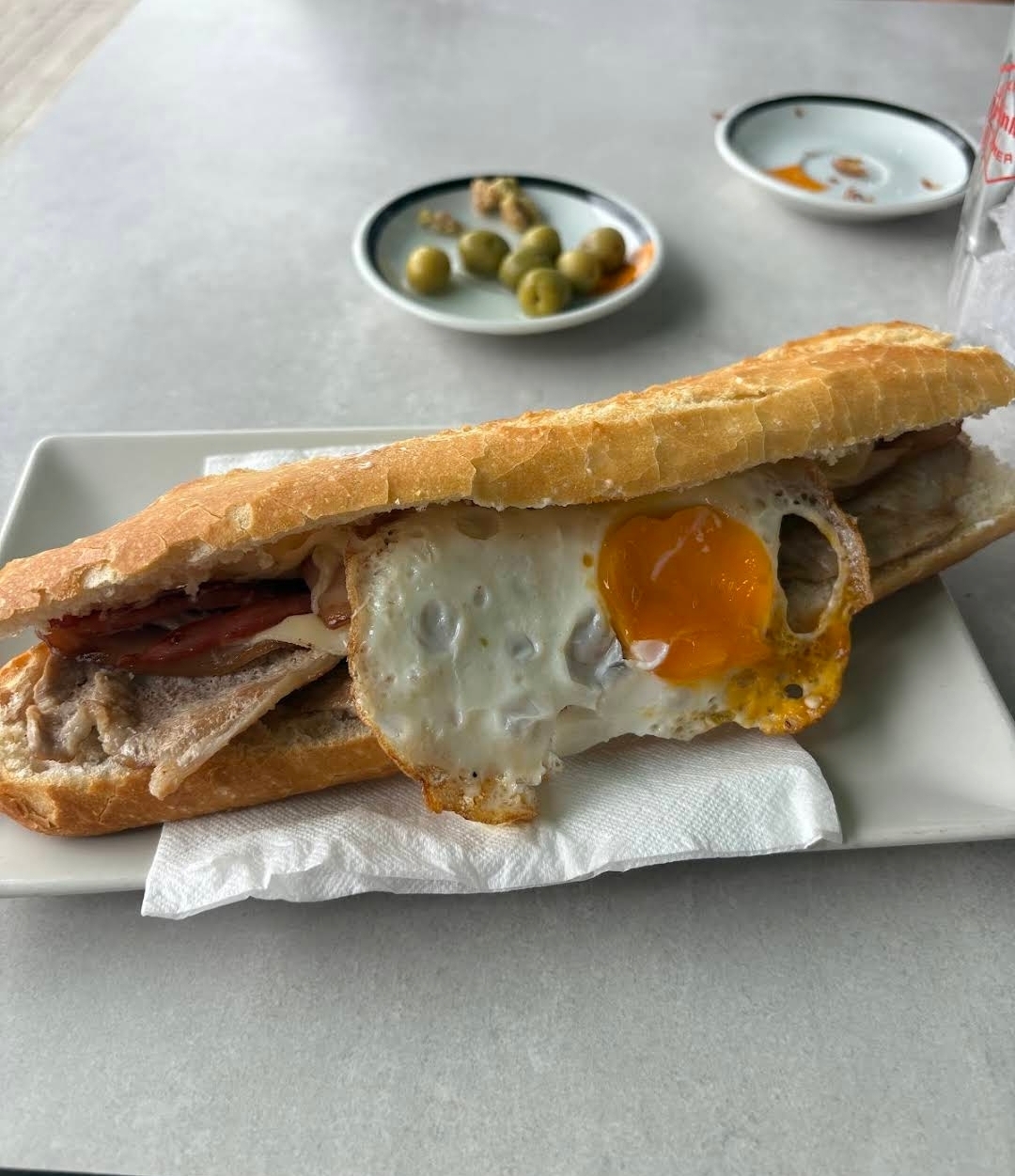 Bocadillo de lomo con huevo frito, olivas y cacaus